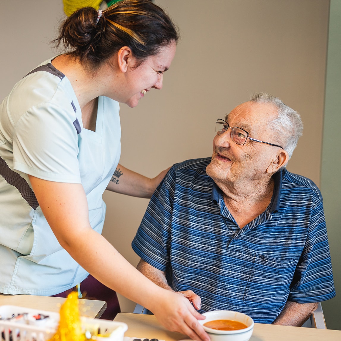Préposée et personne agée qui sourient